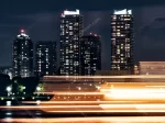 Yokohama light trails ship passing in front of modern skyscrapers japan